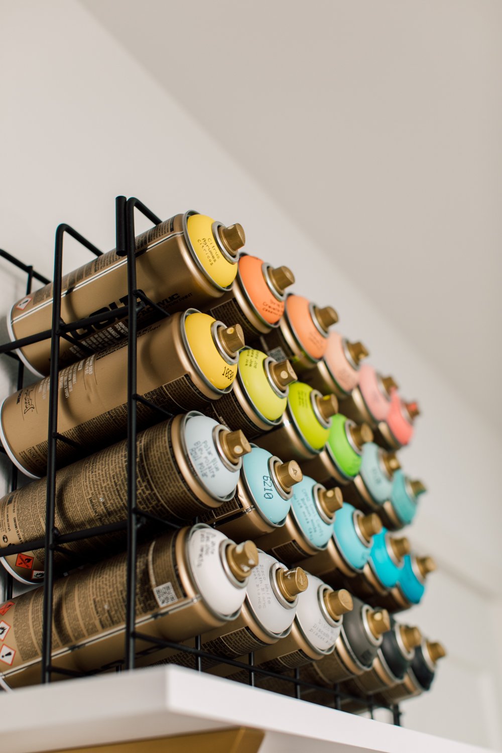 Spray paint in metal rack.