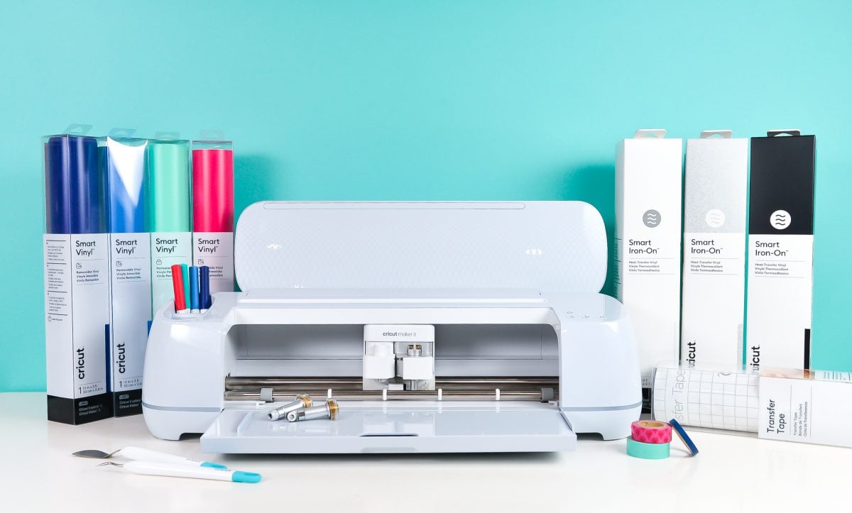 Cricut Maker 3 surrounded by boxes of Cricut Smart materials and Cricut tools.