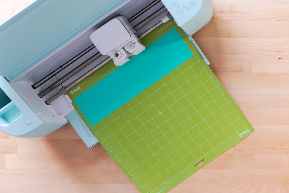 Cricut cutting teal vinyl.